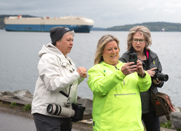 Robin Conover, from left, works with Becky Ivester and Laura Hutchins during the annual photo walk. The Ruby Ace dominates the background, naturally.