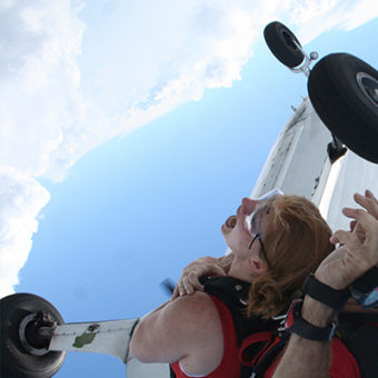 woman jumping out of plane with parachute