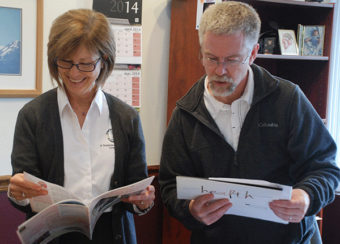 man and woman looking at magazines